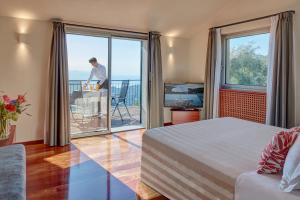 a bedroom with a bed and a view of the ocean at Il Leccio - Luxury Resort Portofino Monte in Santa Margherita Ligure
