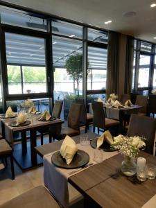 ein Restaurant mit Tischen, Stühlen und Fenstern in der Unterkunft Hotel Eislinger Tor in Eislingen