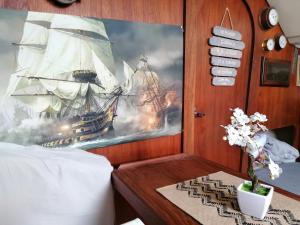 a bedroom with a painting of a ship at Voilier de charme à quai in Saint-Raphaël