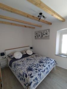 a bedroom with a bed with a blue and white comforter at Apartments Ivana in Trogir