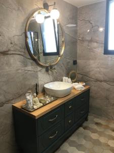 een badkamer met een wastafel en een spiegel bij לאורה in Umm el Shuf
