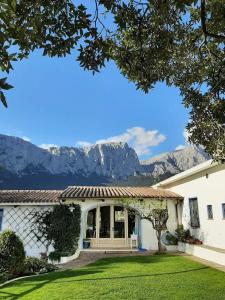 une maison avec des montagnes en arrière-plan dans l'établissement Agriturismo Guthiddai, à Oliena