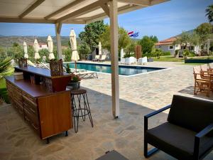 Villa Hylas Luxury Bed & Breakfast Kilada في Kilada: جناح مع مكتب وكرسي بجانب مسبح