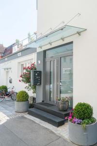 a store front with pots of flowers in front of it at City Wohnung FN L 5 KLIMATISIERT mit Balkon und Küche in Friedrichshafen