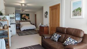 a living room with a couch and a bed at Wood Bank Studio Apartment in Holmfirth