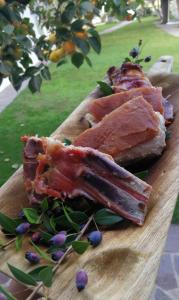een bord met vlees op een snijplank bij Agriturismo Guthiddai in Oliena