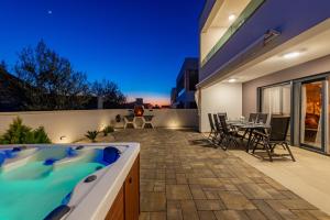 a backyard with a hot tub on a patio at Villa Elite in Vir