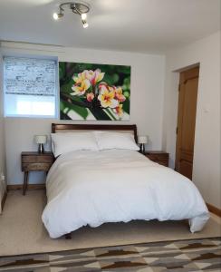 a bedroom with a bed with a painting on the wall at Wood Bank Studio Apartment in Holmfirth