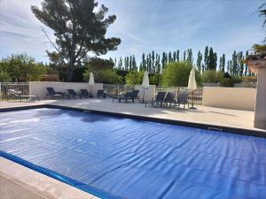 a large swimming pool with chairs and tables and chairs at Domaines des confines in Monteux