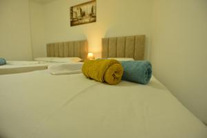 Una cama con dos toallas encima. en Denis Comfort Apartment en Shkodër
