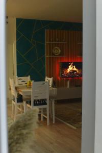 Denis Comfort Apartment في شكودر: غرفة طعام مع طاولة ومدفأة