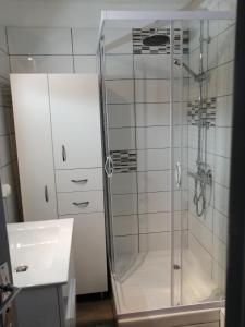 una ducha con una puerta de cristal junto a un lavabo en Risoul 1850 appartement 4 personnes proches pistes. en Risoul