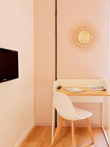 escritorio blanco con silla blanca y TV en Hotel Lemon en Menton