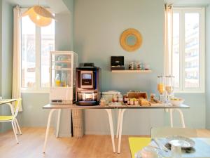 a kitchen with a table with a microwave on it at Hotel Lemon in Menton