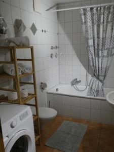 a bathroom with a tub and a toilet and a washing machine at Allgäutraum Ferienwohnung Nr. 1 in Kempten