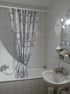 a white bathroom with a tub and a sink at Allgäutraum Ferienwohnung Nr. 1 in Kempten