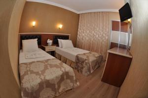 a hotel room with two beds and a television at Epic Hotel in Marmaris