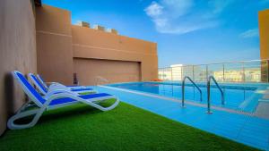a pool with a lounge chair and a swimming pool at Muscat Plaza Hotel in Muscat