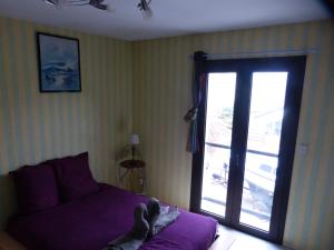 サン・マロにあるBAAN THAI ST MALOのベッドルーム1室(紫色のベッド1台、ガラスのスライドドア付)