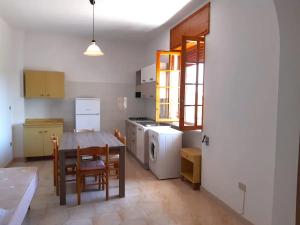 una cucina con un tavolo e un tavolo e sedie di Appartamenti Alba e Tramonto a Marina di Mancaversa Altre 24 foto