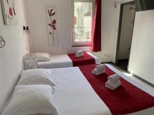 a hotel room with two beds with towels on them at Hostellerie De La Source in Arles
