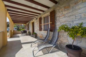 eine Terrasse mit einem Stuhl und einer Steinmauer in der Unterkunft House Braida in Bale