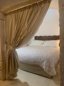 1 dormitorio con 1 cama con dosel en Il trullo del Guelfo en Alberobello