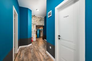 a hallway with blue walls and a white door at Ponte Porton Dining & lodging in Grožnjan