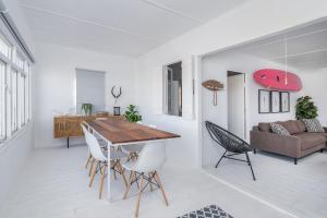 a kitchen and living room with a wooden table and chairs at Live Simply Beach House in Stilbaai