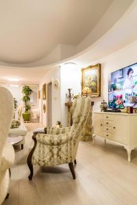 een woonkamer met een tv en een stoel bij Luxury Apartment Sara in Umag