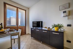 Habitación con cocina con mesa y TV. en Arianna Apartment, en Sovicille