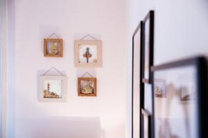 a wall of framed pictures on a white wall at Konstantina & Evgenia Deluxe Apartment in Nea Peramos