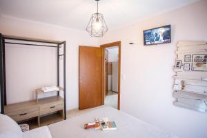 a bedroom with a mirror and a bed and a dresser at Konstantina & Evgenia Deluxe Apartment in Nea Peramos