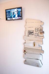 a stack of books on a wall with a tv at Konstantina & Evgenia Deluxe Apartment in Nea Peramos