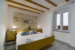 a bedroom with a large bed and a stone wall at House Braida in Bale +31 photos