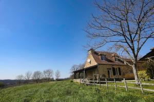 une vieille maison en briques sur une colline avec un arbre dans l'établissement Maison avec vue magnifique, à Loubejac 3 autres photos