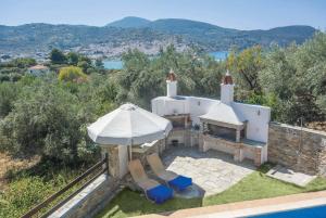 スコペロスにあるAlexandra Metoxi Skopelosのパラソルと椅子、プール付きの家
