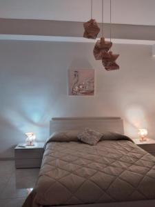 a bedroom with a bed with two night stands and two lamps at Casa di Tina in Castellana Grotte