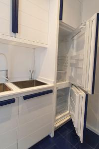 a kitchen with white cabinets and an empty refrigerator at Nel blu dipinto di blu in Ravello