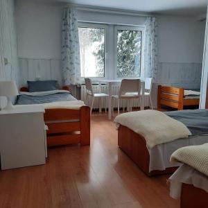 a bedroom with two beds and a table and chairs at Przystanek Podgórze in Duszniki Zdrój