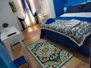 a bedroom with a bed and a table and a rug at Al Quindici Scilla in Scilla
