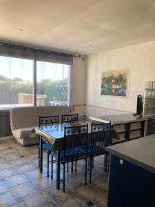 ein Wohnzimmer mit einem Tisch, Stühlen und einem Sofa in der Unterkunft Mas Catalan in Torreilles