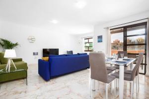 uma sala de estar com um sofá azul e uma mesa em FTV Holidays Homes em Corralejo