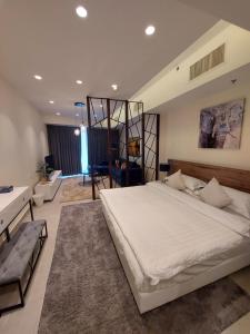 a bedroom with a large bed and a living room at Luxury Studio - Damac Tower Amman in Amman