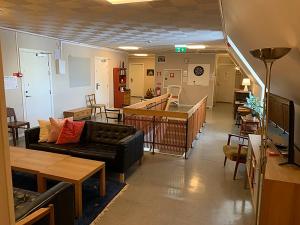 ein Wohnzimmer mit einem Sofa, Tischen und Stühlen in der Unterkunft Nyköpings Vandrarhem in Nyköping