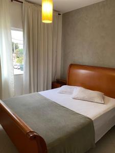 a bedroom with a large bed with a window at COMFORT DUPLEX in Rio das Ostras