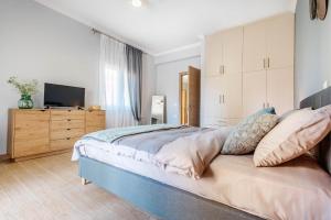 a bedroom with a large bed and a television at Eftychia's Garden House in Kompítsion