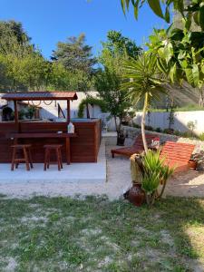 un giardino con panchina e gazebo di Villa Zagara a Gioiosa Ionica