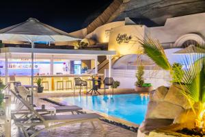 una piscina in un resort con sedie e bar di Santoterra Antigua Suites a Karterados