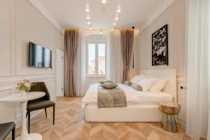 a white bedroom with a bed and a table at Luxury Rooms L'Avenue 2 Split in Split